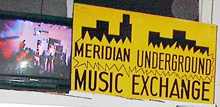 The yellow Meridian Underground Music Exchange sign with the skyline logo, around 2002